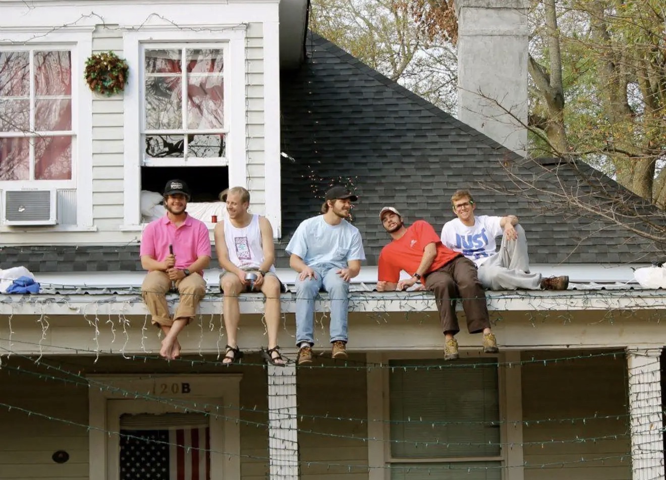 Guys lined up sitting on the porch roof at 120 Springdale